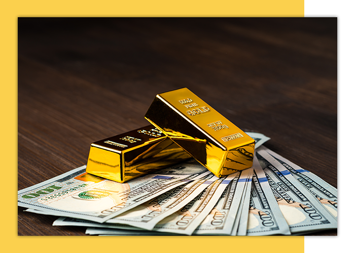 Gold bars on top of one-hundred dollar bills.